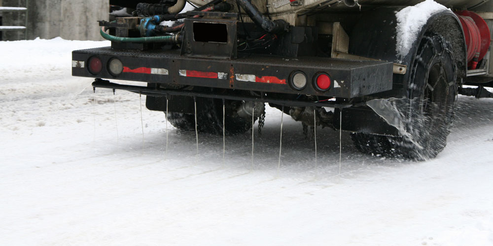 Truck spraying brine on icy roadway