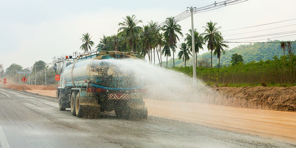 Water tanker truck spraying roadway
